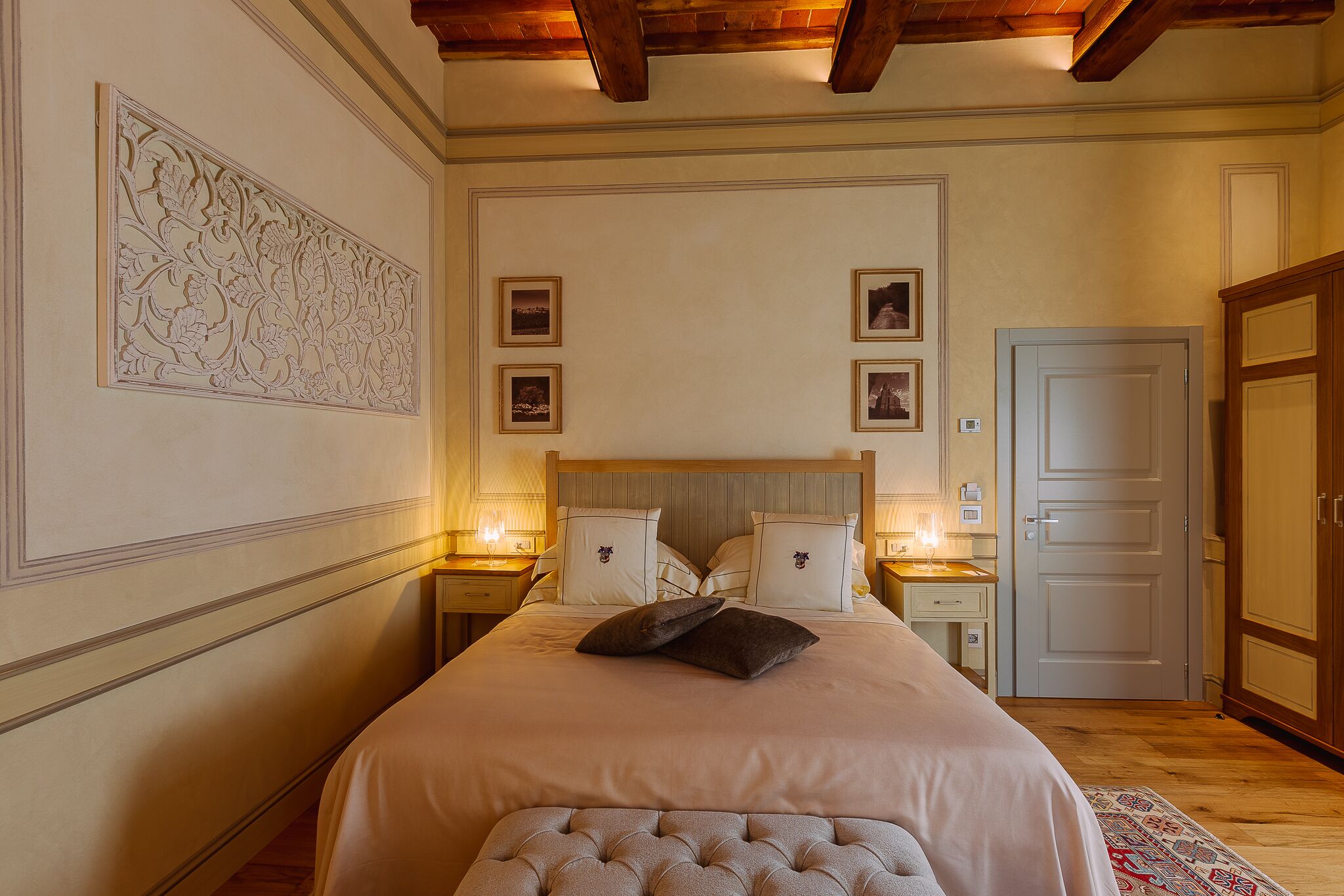 Ein Schlafzimmer mit einem großen Bett, zwei Nachttischen, einer Kopfteil und einer Tür.