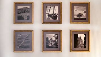Sechs gerahmte Fotografien verschiedener Landschaften und Gebäude an einer Wand.