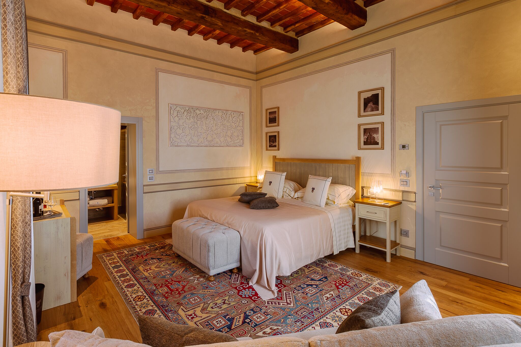 Ein Schlafzimmer mit einem Bett, Nachttischen, einem Teppich mit Muster und einer Tür.