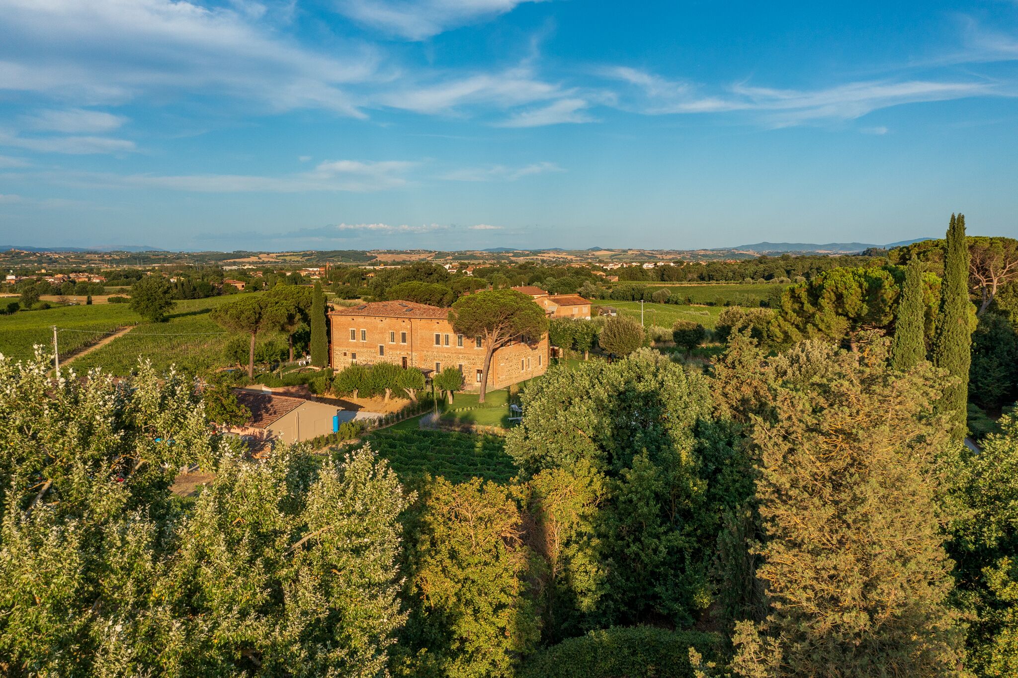 A large building surrounded by lush greenery and fields.