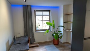 Eine moderne Küche mit Einbaukühlschrank, einem Esstisch mit Laptop und einer Topfpflanze.