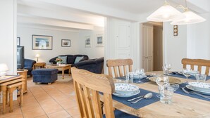 Un comedor con una mesa de madera dispuesta para cuatro personas, rodeada de sillas de madera.