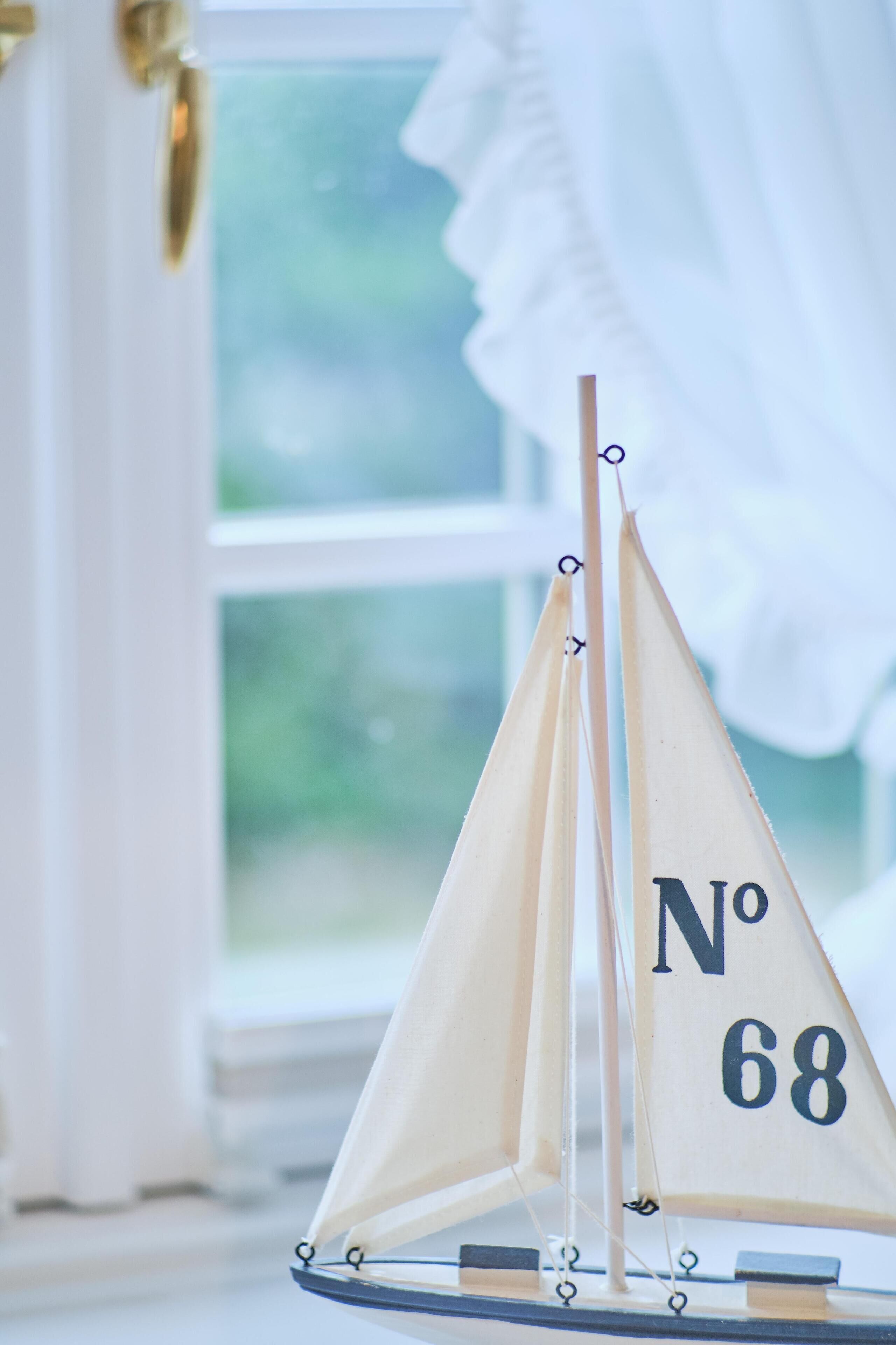 Un velero modelo con el número '68', colocado sobre una mesa.