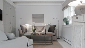 A modern living room with a sofa, coffee table, and decorative items. - Wohnung Über Zwei Ebenen ca. 90m² für bis Vier Personen (Sylt / OT Keitum)