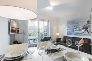 Enjoy meals in this dining area with a large table for four, overlooking the outdoor patio and garden.