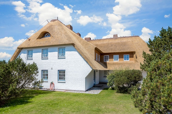 Traditional house with a symmetrical facade and well-maintained surroundings.