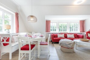 Relax in this stylish room with a dining area for four, a comfortable sofa, and a large window with a woven basket.