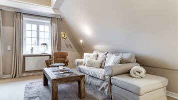 A cozy living room with a sofa, a wooden coffee table, and a chair.