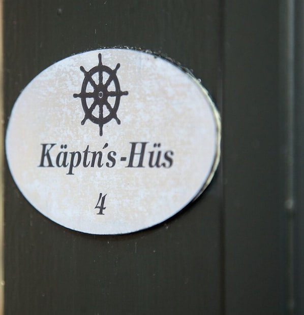 A sign with a ship's wheel symbol and the text "Kapt'n's-Hüs 4". - Käptn's Hüs - generously proportioned apartment over two levels (Sylt / OT Keitum)