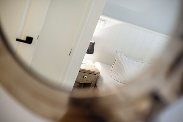 Una camera da letto con un letto, un comodino e una lampada.
