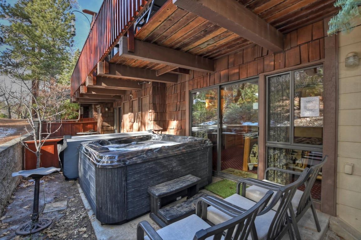 Un bain à remous avec une terrasse en bois, des sièges extérieurs et une vue sur les environs.