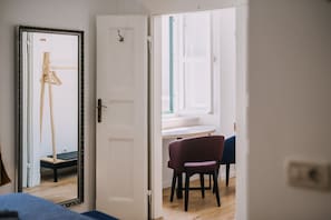 Relax in a serene space with a comfortable bed, artistic touches, and a view from the window.