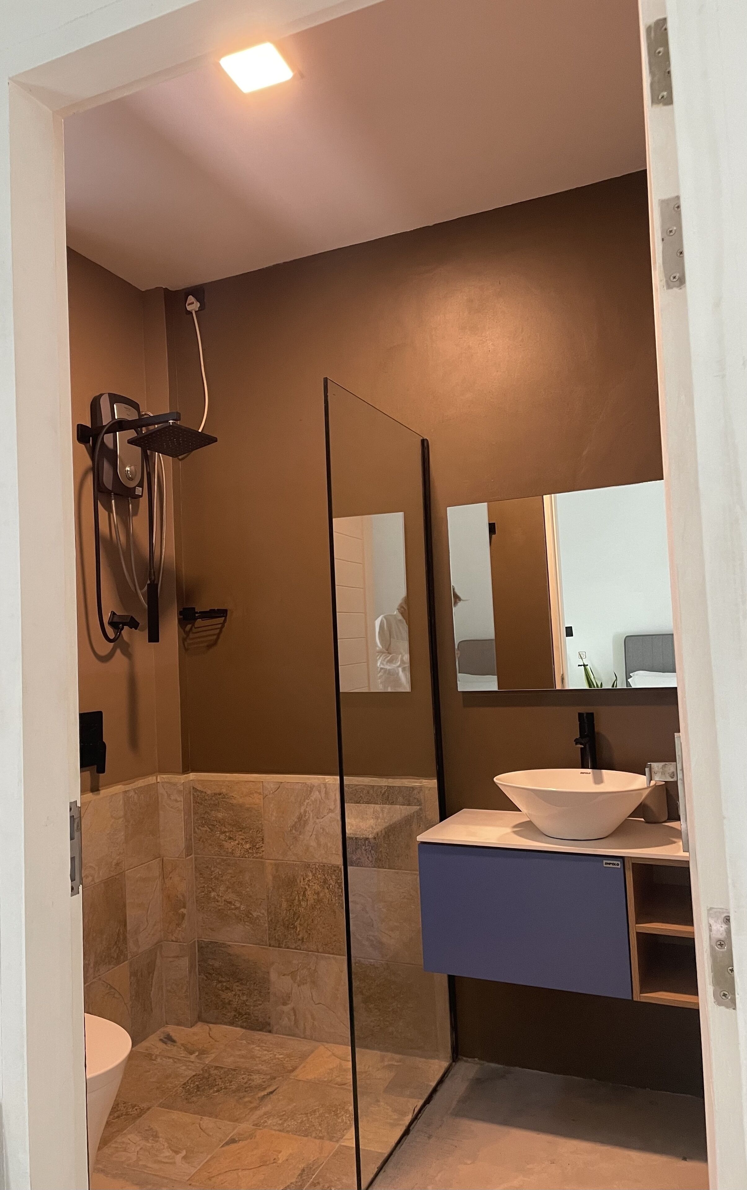 A modern bathroom with a shower, a sink, and a large mirror.
