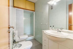 A bathroom with a toilet, sink, and shower area. - Apartamento Majestic (Lloret de Mar)