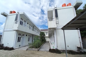 A multi-story building with a central courtyard, featuring a staircase leading to an upper level.