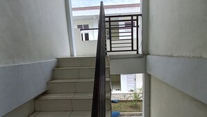Un escalier menant à un balcon d’où l’on peut admirer le ciel et un bâtiment en arrière-plan.