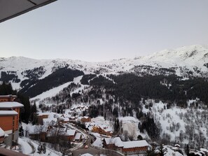 A snow-covered mountain village with wooden buildings and a ski slope. - Functional Apt near slopes, shops, with balcony & WiFi in Méribel (Méribel)