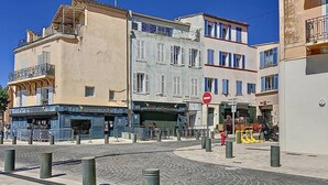 A cobblestone street with buildings, a no entry sign, bollards, and a closed shop. - Bright T2 Apartment at the Old Port, La Ciotat (La Ciotat)
