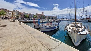A marina with boats docked, a paved walkway, and buildings in the background. - Bright T2 Apartment at the Old Port, La Ciotat (La Ciotat)