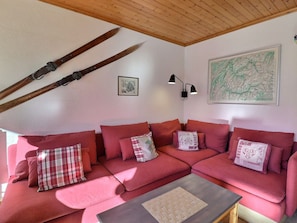 A cozy room with a red sofa, a small table, and a map on the wall.