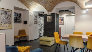 A dining area with yellow chairs, a wooden table, and a brick ceiling. - Cozy guesthouse in the center of Rome (Roma)