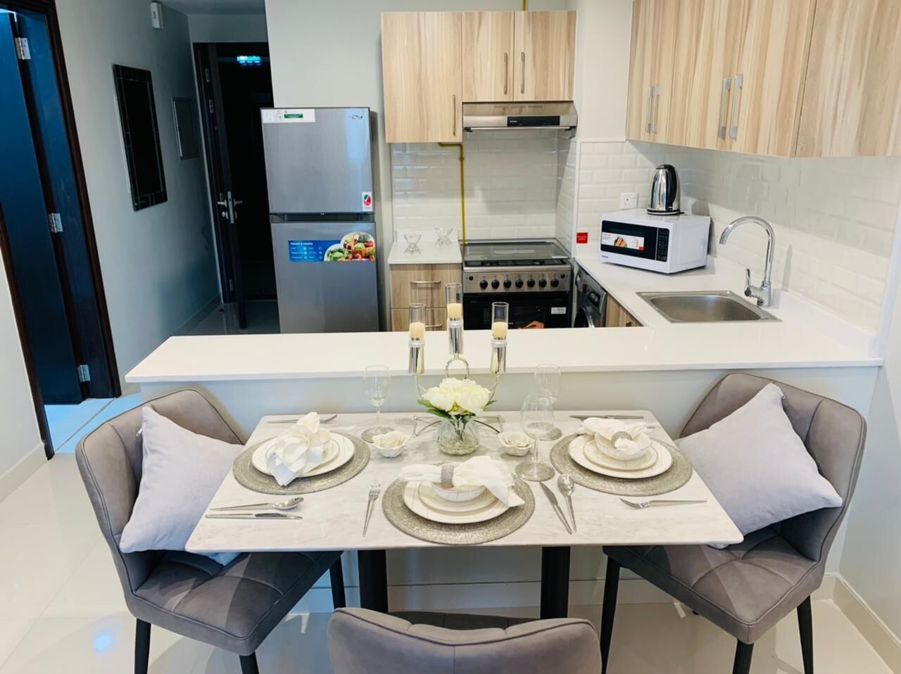 A modern kitchen with a dining area set for four.