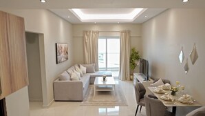 Una sala moderna con sofá, mesa de centro y comedor.