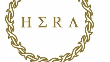 Un logo comportant le texte « HERA », encadré par un motif décoratif en forme de chaîne.