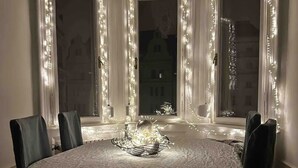Uma área de jantar com uma mesa redonda, cadeiras e um arranjo decorativo.