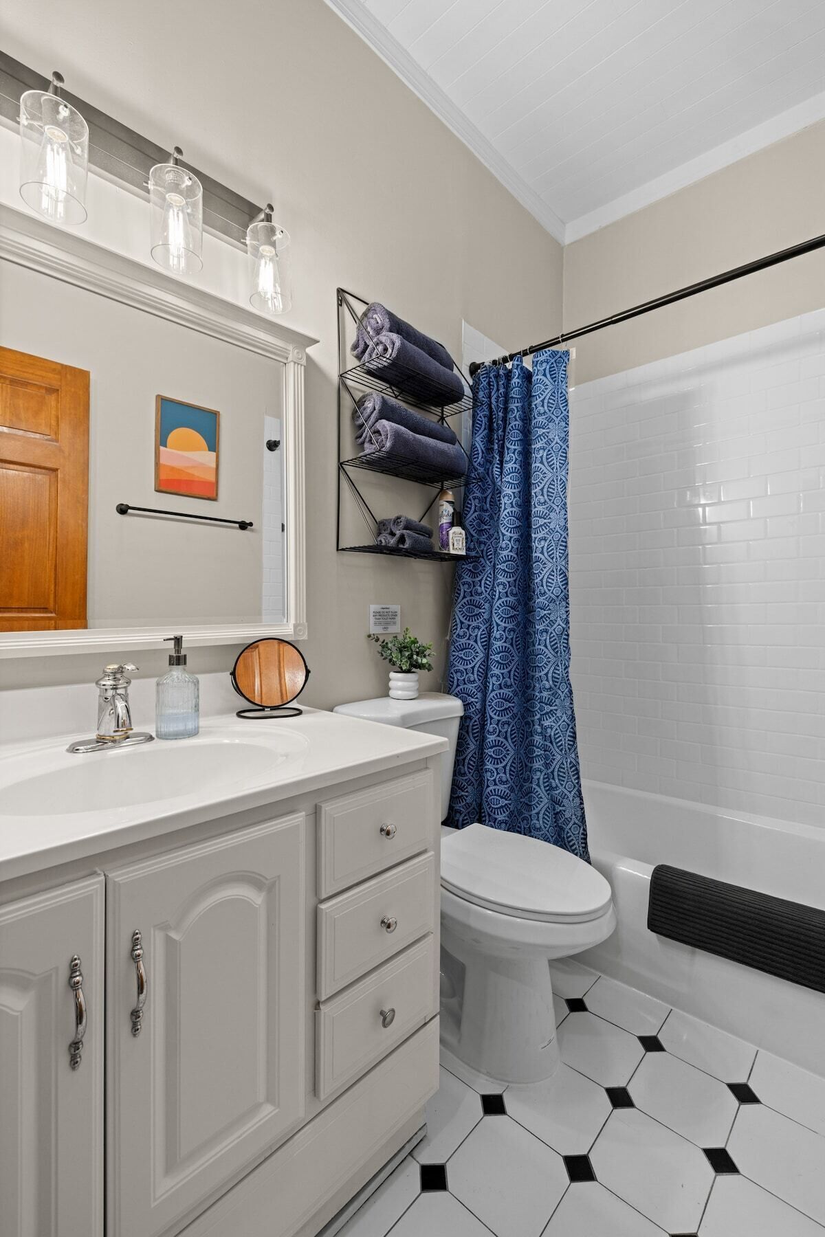 Une salle de bain avec un lavabo blanc, des toilettes, un rideau de douche et un porte-serviettes.