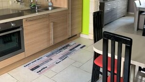 Una cucina con mobili in legno, un lavello e un'area pranzo con tavolo e sedie.