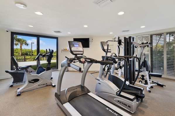 A gym with treadmills, elliptical machines, and weight equipment. - Beachfront 3BR condo with pool, wifi, and Marco Island views. (Marco Island)