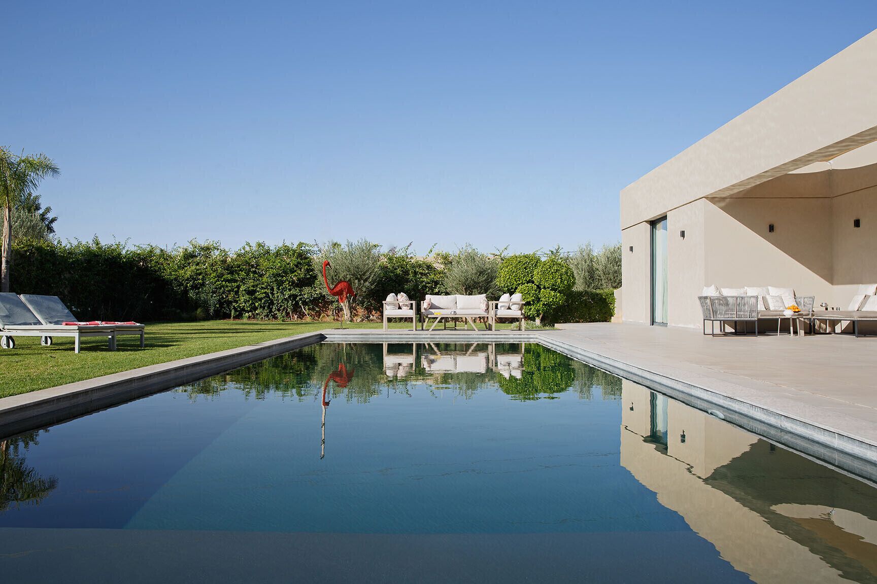 A swimming pool with lounge chairs and a building in the background.