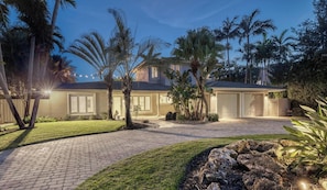A two-story house with a paved driveway, palm trees, and a well-maintained lawn. - LVS New Royale 80ft Waterfront/Wlk2Beach/HotPool/Spa/KitchenBBQ (Lauderdale-by-the-Sea)