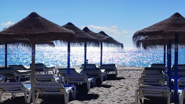 A beach with rows of sun loungers and thatched umbrellas. - Apartamento Para 4-6 pax en la Costa del Sol, Mijas Málaga. Acepta Mascotas (AN)