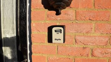 Una puerta con un picaporte negro y una pared de ladrillo con un letrero de 'Diyife'.