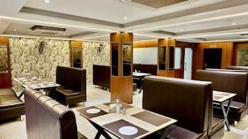 Un restaurante con asientos tipo cabina, techos altos y paredes de mármol.
