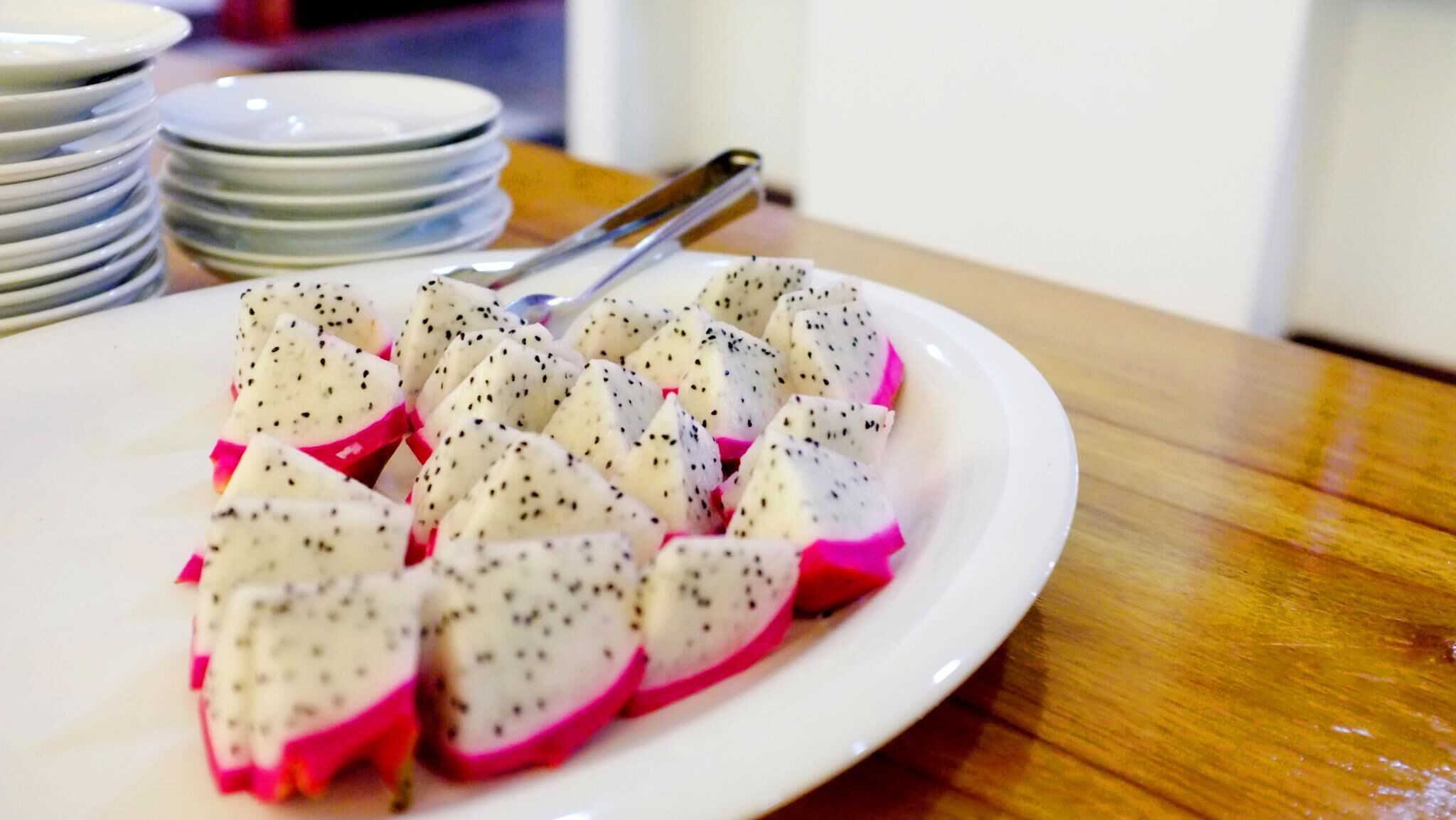 Una fuente de rodajas de pitaya sobre un plato blanco.