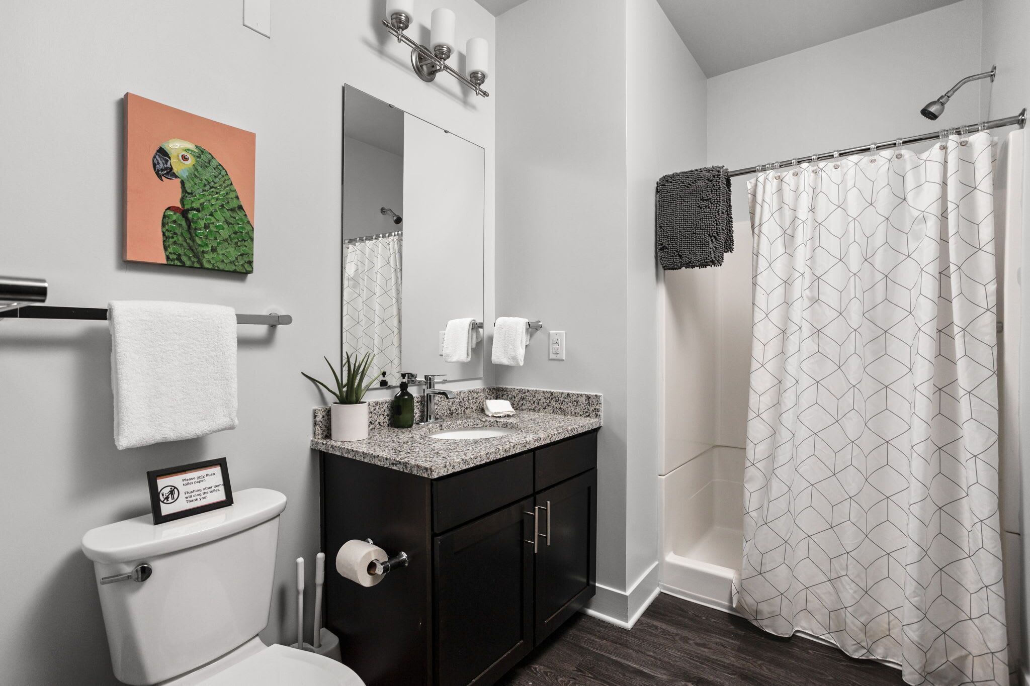 A modern bathroom with a toilet, sink, and shower.