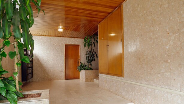 A spacious hallway with a wooden ceiling, a marble floor, and a staircase leading to a door. - Pateo IN Lapa City Center by Vacationy (Porto)