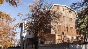 A large, rustic building with a prominent entrance and a staircase leading up to a door. - 2 Bedroom Apartment in Celico (Celico)