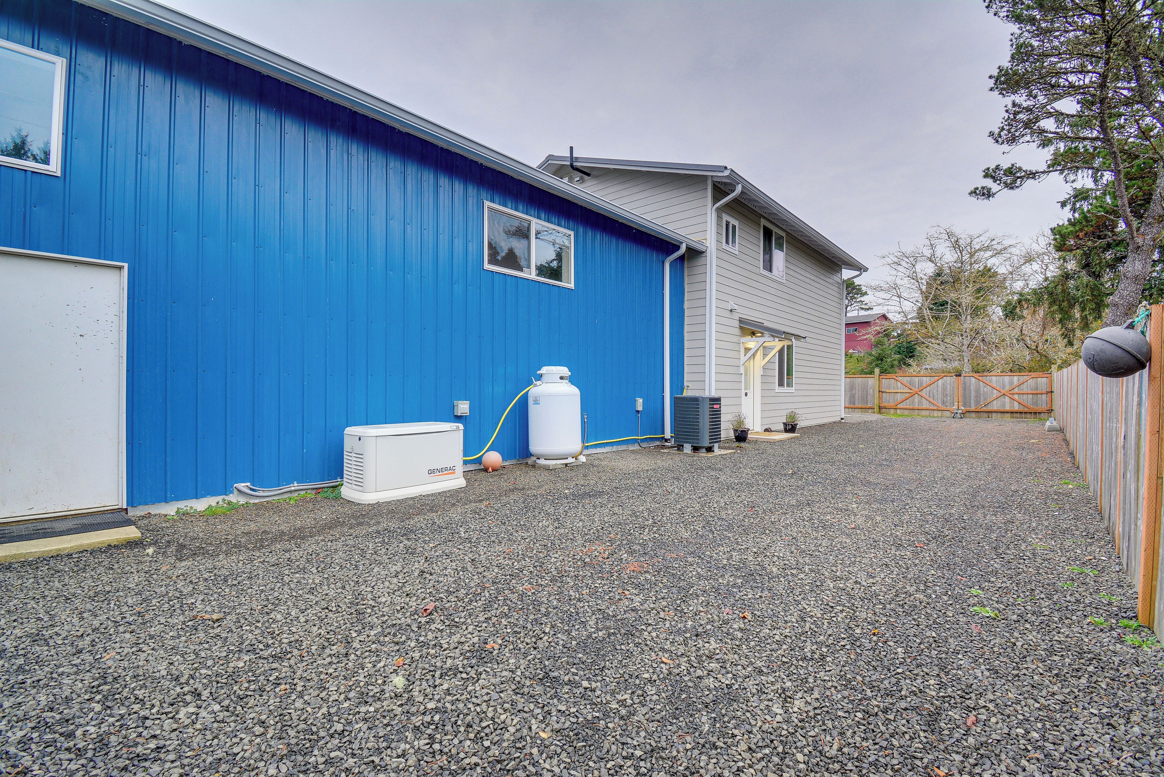A building with a blue exterior and a gravel driveway.