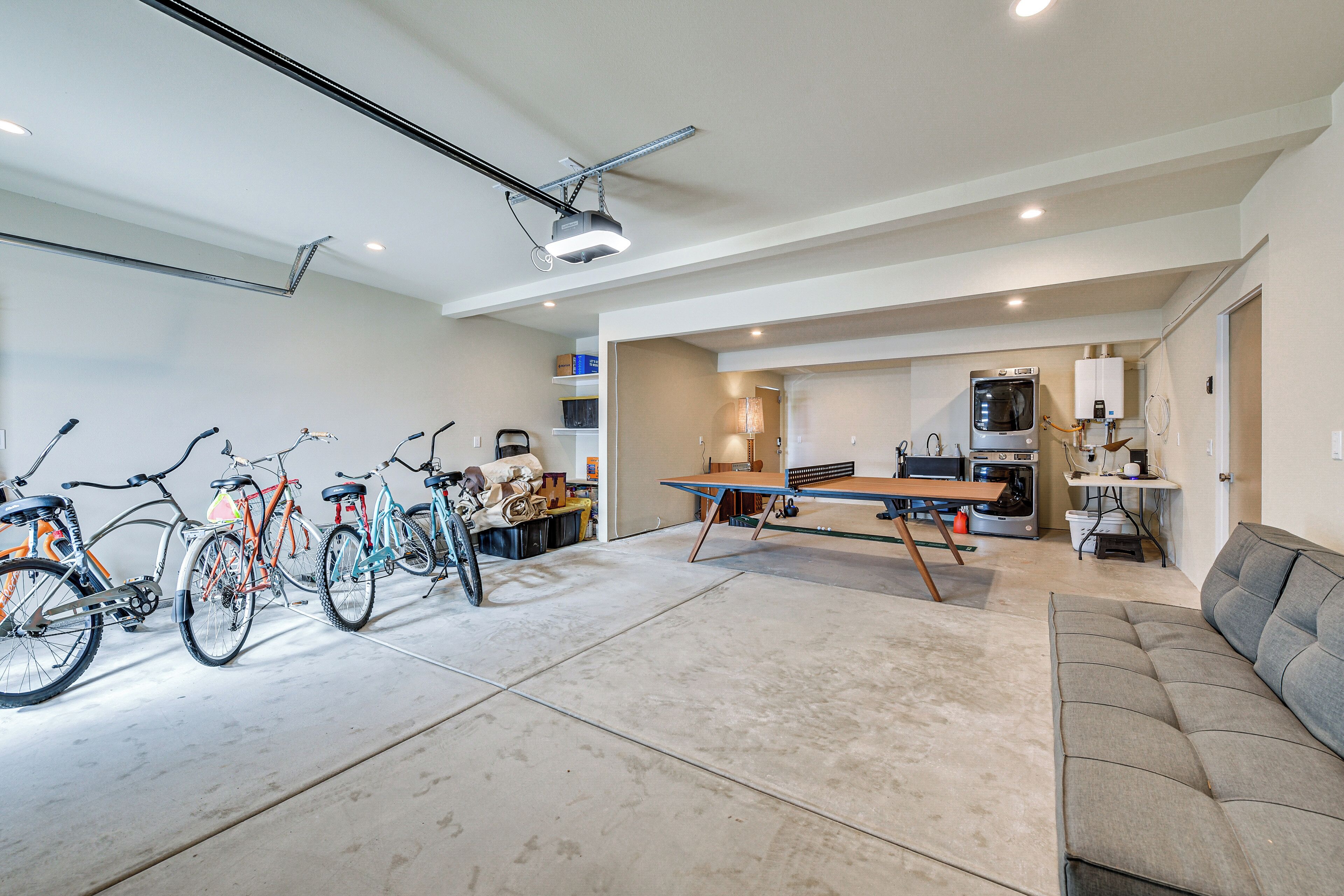 A spacious living area with a sofa, a dining table, and a kitchen area with appliances. There are bicycles parked against the wall.
