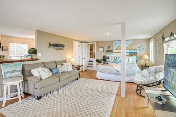 A well-lit living room with a sofa, a coffee table, and a TV. There is a staircase leading to another room. - Waterfront Daytona Escape w/ Pool & Game Room! (Daytona Beach)