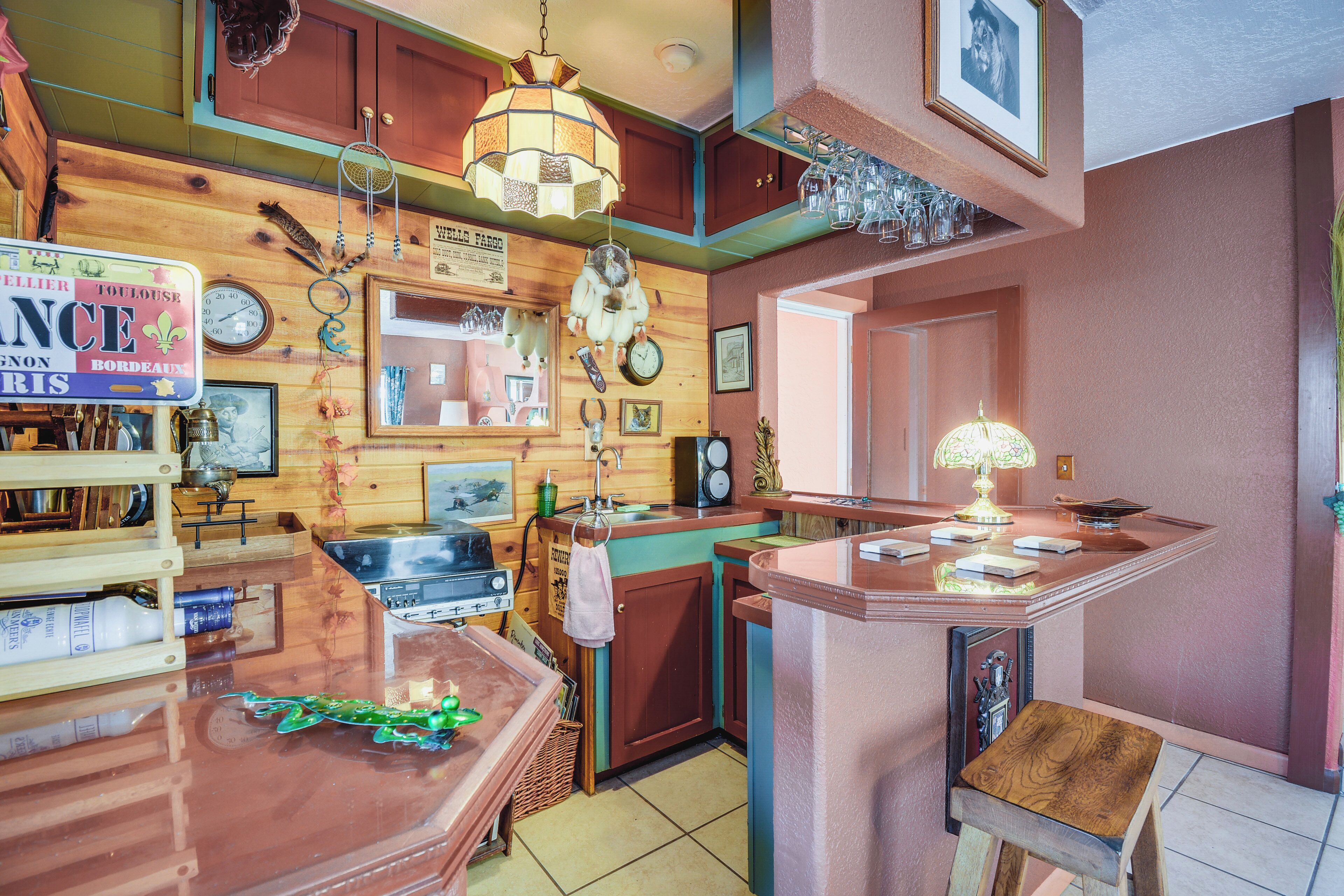 Una cocina con armarios de madera, un lavabo, una estufa y varios utensilios de cocina.