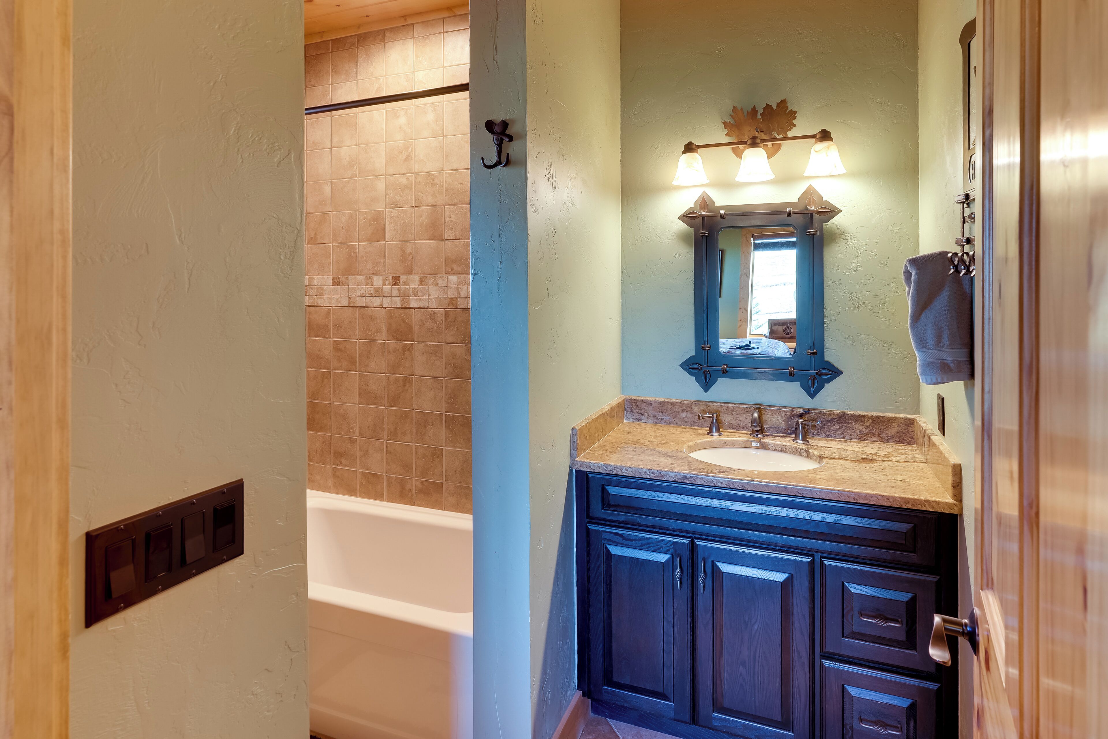 A bathroom with a bathtub, a sink, and a mirror.