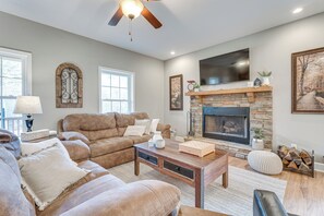 Ein gemütliches Wohnzimmer mit Kamin, Ledersofas und einem Flachbildfernseher.