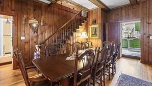 A dining area with a wooden table and chairs, a staircase, and a kitchen visible through an open door. - Gorgeous, downtown house! (Perryville)
