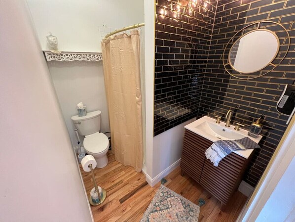 Une salle de bain avec des toilettes, un rideau de douche et un lavabo avec un miroir.