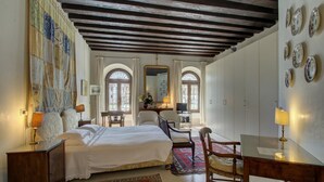 Ein Hotelzimmer mit einem großen Bett, einem Schreibtisch, zwei Stühlen, einem Fernseher und einem dekorativen Spiegel.